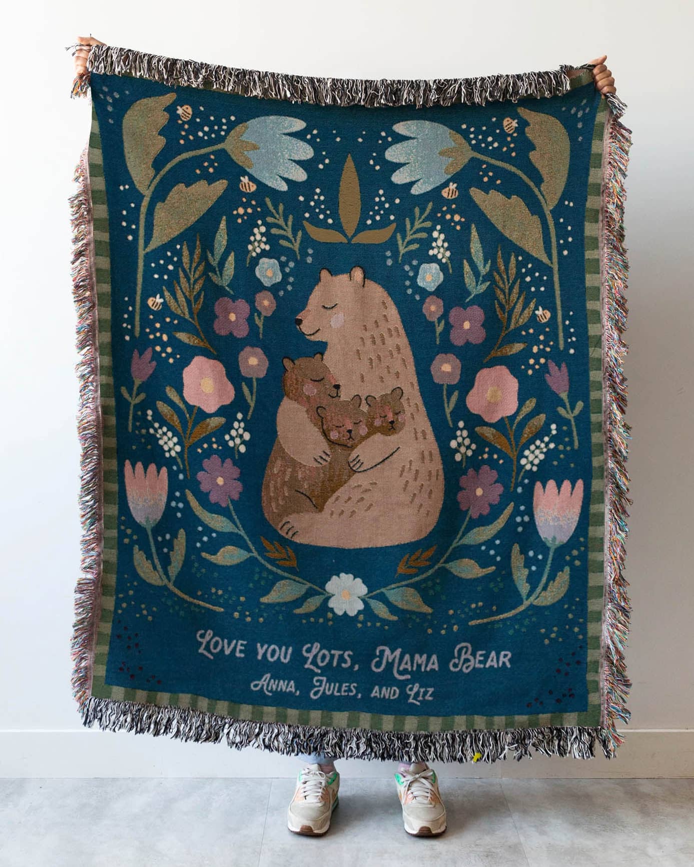 Decorative blanket with bear design and floral elements on a plain background